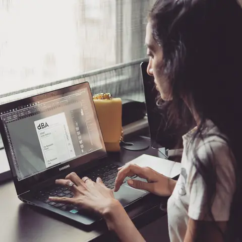 Faten M working on a design on her laptop