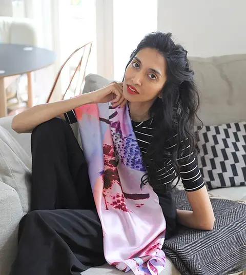 Faten M, founder of Londonfatcat Interiors, seated on a sofa