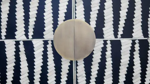 Close-up of the moon-shaped brass handle on the Sagmeister wardrobe's inlaid doors