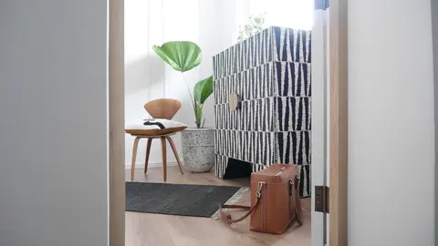 Sagmeister guest wardrobe in black and white mother of pearl inlay with a brass moon handle, beside a bentwood chair